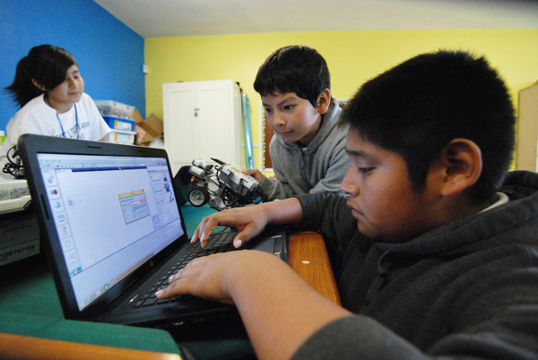 Partners Brandon Medina, center, and Victor Perez work on a programming solution.