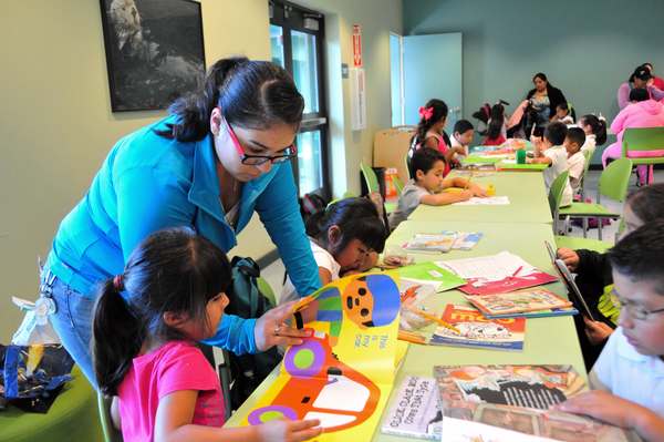 Tutor Elizabeth Pacheco has her hands full with different homework assignments at the Cesar Chavez Library’s homework center in Salinas.