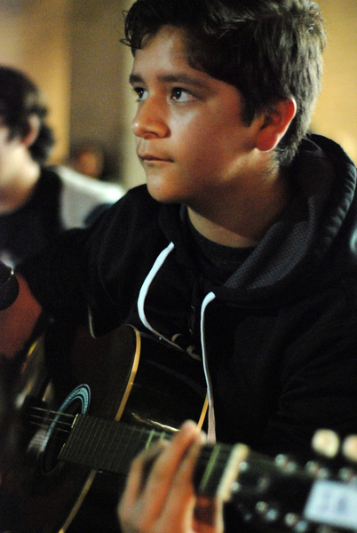 Gustavo Montoro, 13, an advanced student in Felix Miranda's guitar class, waits for his cue at a public performance in front of the CHISPA building during First Friday, a Salinas tradition on Main Street each month.