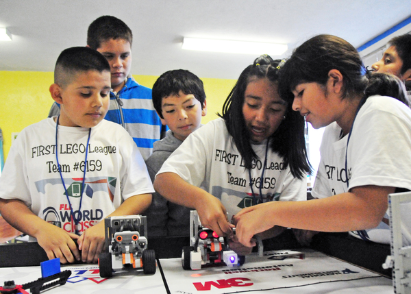 From left, Jonathan Baires, Jose Jimenez, and Brandon Medina watch Dayanara Martinez and Amy Garcia work out a quirk in their robot.