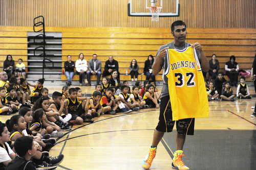 During the final regular session of 2014 at Alisal High School in Salinas, Gil Basketball Academy founder Jose Gil, right, holds up an autographed Magic Johnson jersey to be raffled off.