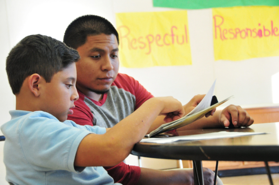 Hartnell College sophomore Stephen Corona, 24, helps Yacer Picazo, a Sherwood Elementary School student, with his English reading.